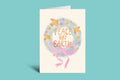 Greeting card with 'Peace on Earth' text and decorative elements on a light green background
