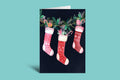 Christmas card with stockings and holly on a black background