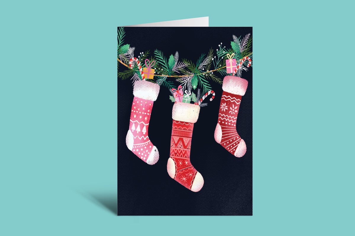 Christmas card with stockings and holly on a black background