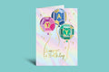 Colorful birthday card with geometric balloons and 'Happy Birthday' text on a pastel background