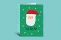 Green Christmas card with a cartoon Santa Claus face and 'Ho Ho Ho' text on a light green background.