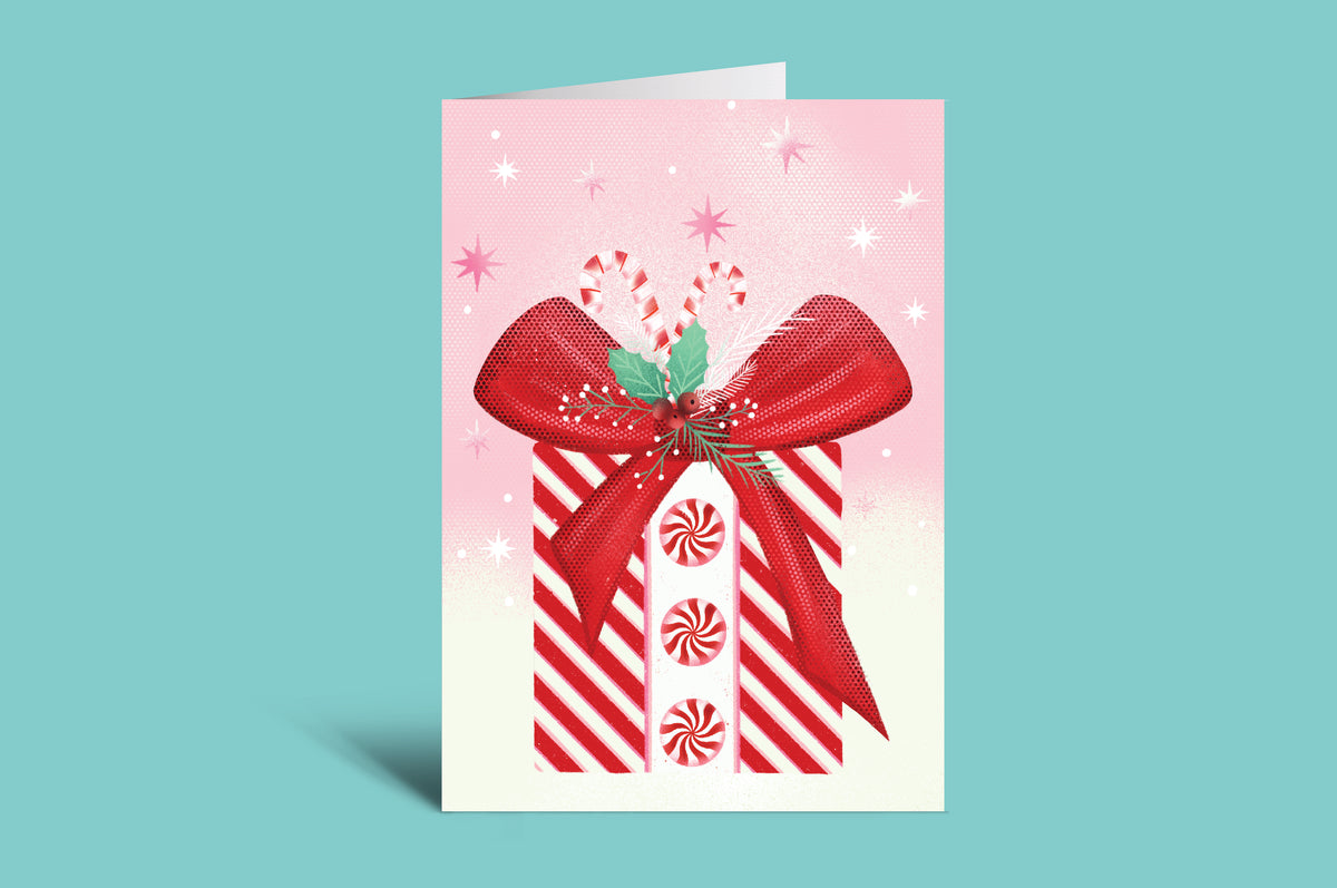 Greeting card with a red bow and candy canes on a pink background