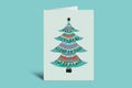 Greeting card with a colorful Christmas tree design on a green background