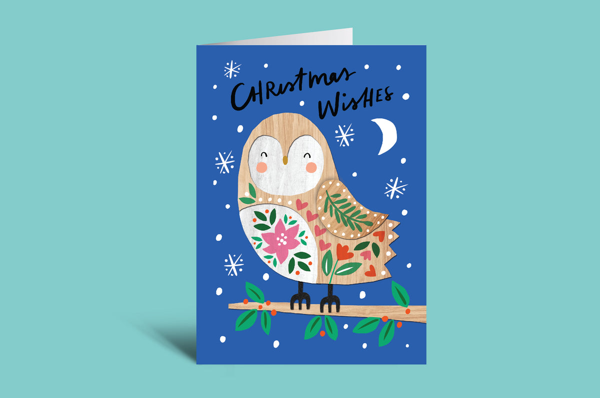Christmas card with a penguin holding a floral branch on a blue background