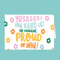 Motivational card with colorful text and flowers on a teal background