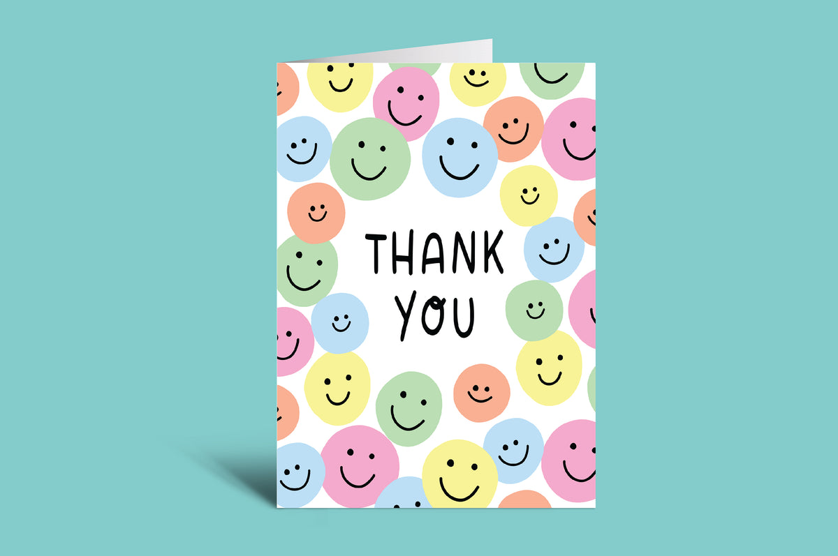 Greeting card with colorful smiley face pattern and 'Thank You' text on a green background