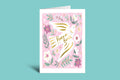 Greeting card with floral design and 'Peace on Earth' text on a pink background