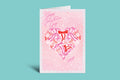 Valentine's Day card with pink polka dots and red and pink ribbons on a green background