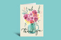 Greeting card with floral design and 'thank you' text on a green background