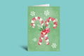 Christmas card with candy canes and a bow on a green background