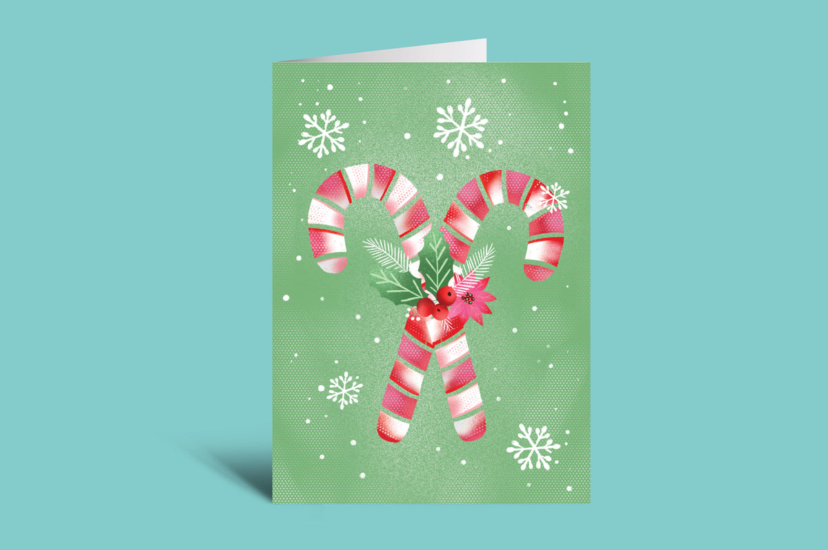 Christmas card with candy canes and a bow on a green background