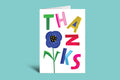 Colorful 'THANKS' card with a blue flower on a green background