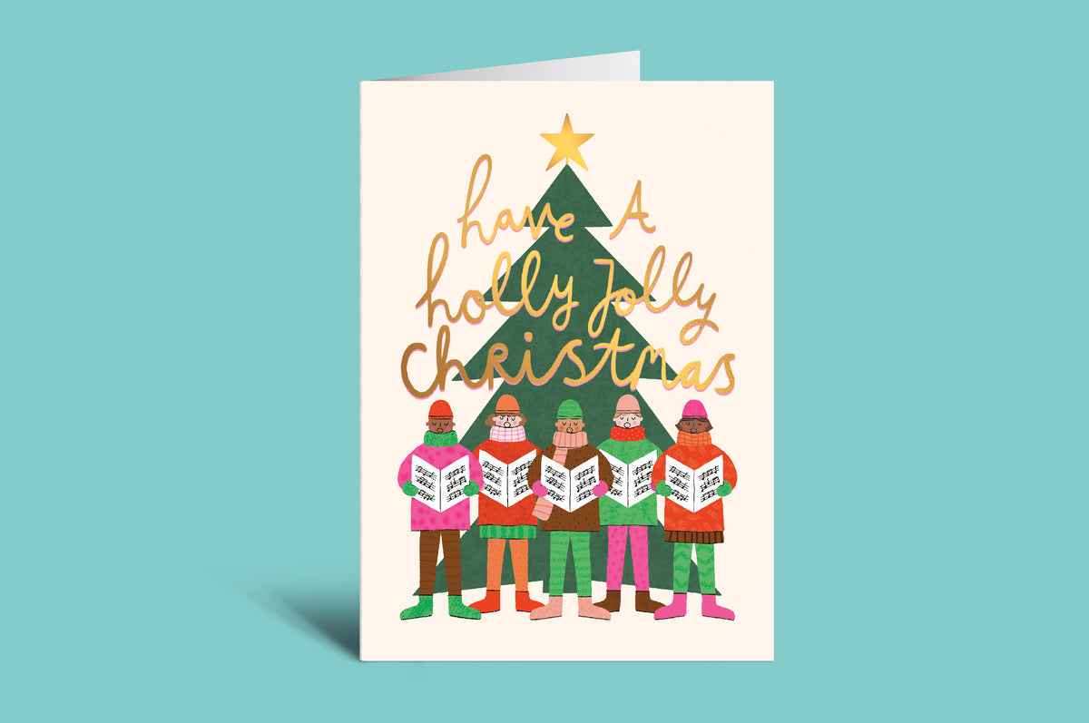 Christmas card with people singing in front of a Christmas tree and 'holly jolly Christmas' text on a green background