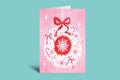 Greeting card with red snowflake and bows on a pink background
