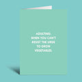 A mint green greeting card with white text that reads 'ADULTING: WHEN YOU CAN'T RESIST THE URGE TO GROW VEGETABLES.' shown against a solid teal background.