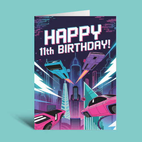 A retro-futuristic 11th birthday greeting card featuring a neon cyberpunk cityscape with flying cars and the text 'HAPPY 11th BIRTHDAY!' in bold white letters, shown standing upright against a solid light teal background.