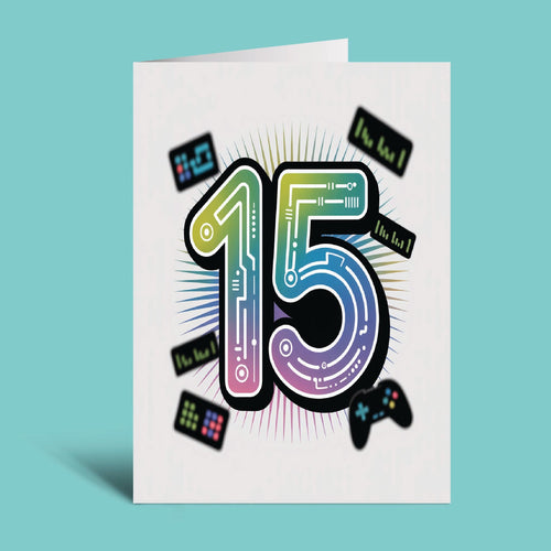 A white greeting card standing upright against a light aqua background, featuring a large colorful '15' with circuit-board lines and small game-themed graphics including a controller and text labels.