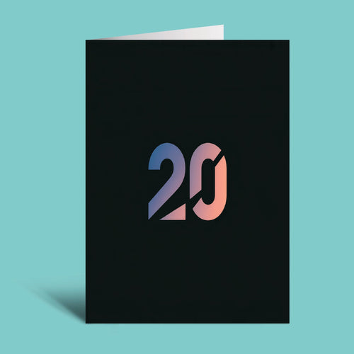 A black greeting card standing upright on a light aqua background, featuring a stylized '20' in a blue-to-pink gradient on the front.