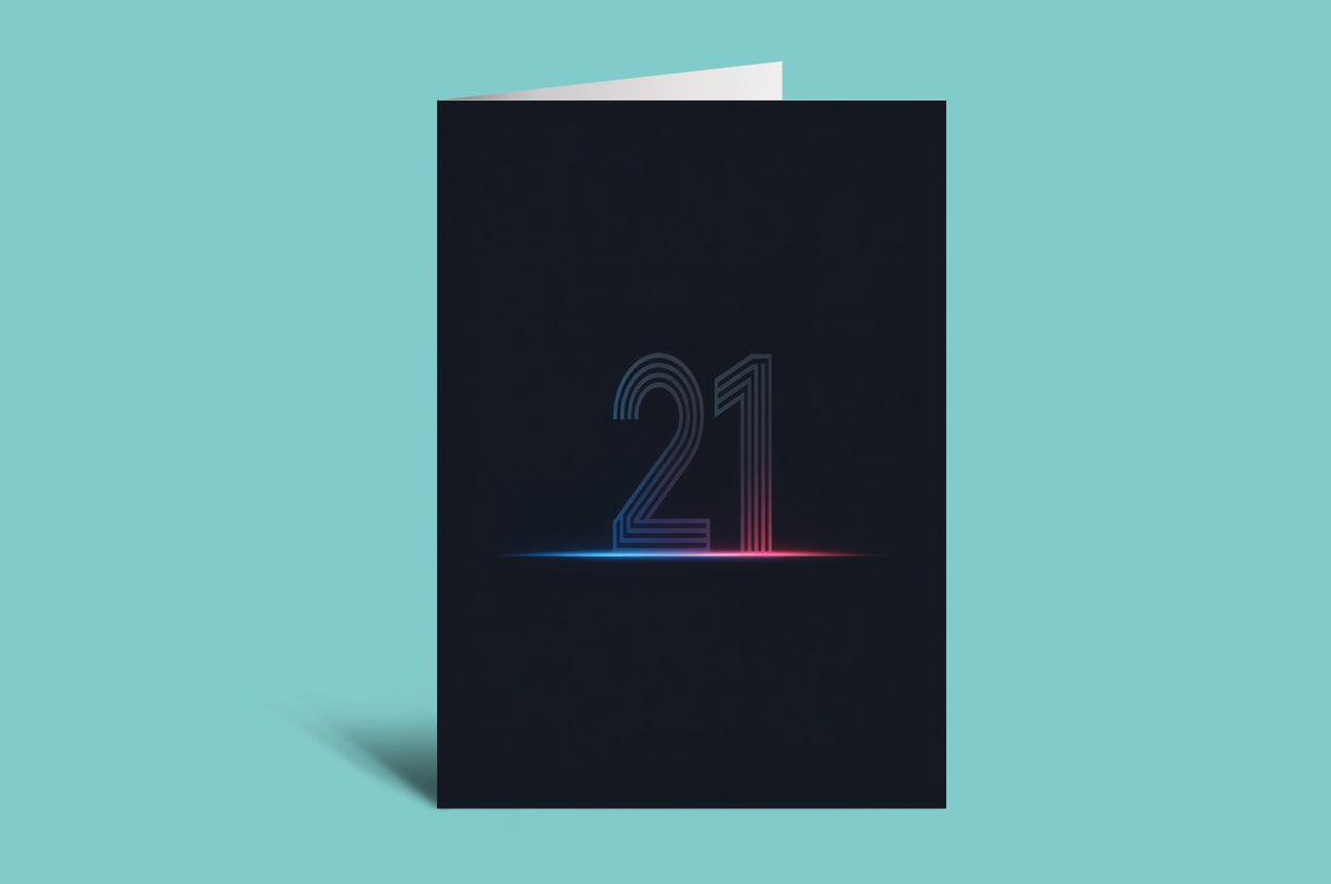 A black greeting card standing upright on a light aqua background, featuring the number 21 in a glowing neon-style outline with a blue-to-pink gradient and a horizontal light effect.