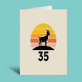 A vertical greeting card with a cream background stands against a solid turquoise background. The card features a retro sunset graphic with yellow, orange, and pink stripes, a black goat silhouette, and the number 35 below.