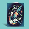 A vertical greeting card with a space-themed design reading 'Happy 6th Birthday' in large white text, featuring a rocket ship, planets, stars, and a colorful trail on a dark blue background. The card is shown standing upright against a light aqua backdrop.