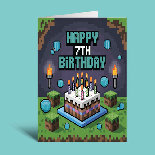 A pixel-art style birthday card standing upright on a light aqua background. The card reads “HAPPY 7TH BIRTHDAY” above a Minecraft-inspired birthday cake with candles, torches, blocks, and blue orb graphics.