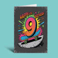A 9th birthday greeting card featuring a colorful comic-style graphic of the number 9 on a skateboard with the text 'HAPPY 9TH BIRTHDAY' on a dark gray background, shown standing against a solid light blue backdrop.