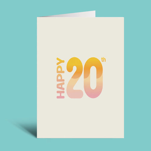A cream-colored greeting card standing upright against a solid turquoise background. The card features the text 'HAPPY 20th' in a vertical, modern font with a warm yellow-to-pink gradient fill.