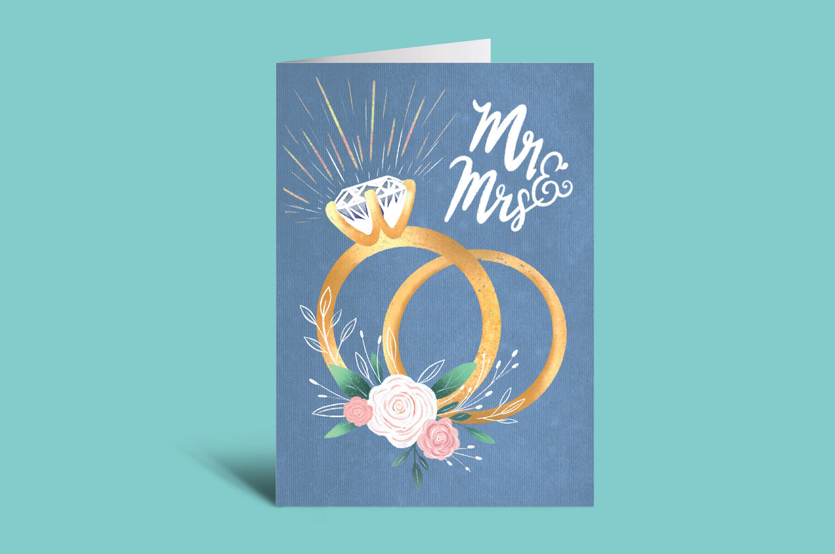 Greeting card with wedding rings and flowers on a blue background