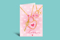 Card with heart-shaped key and bow necklace illustration on a pink background with 'love' text.