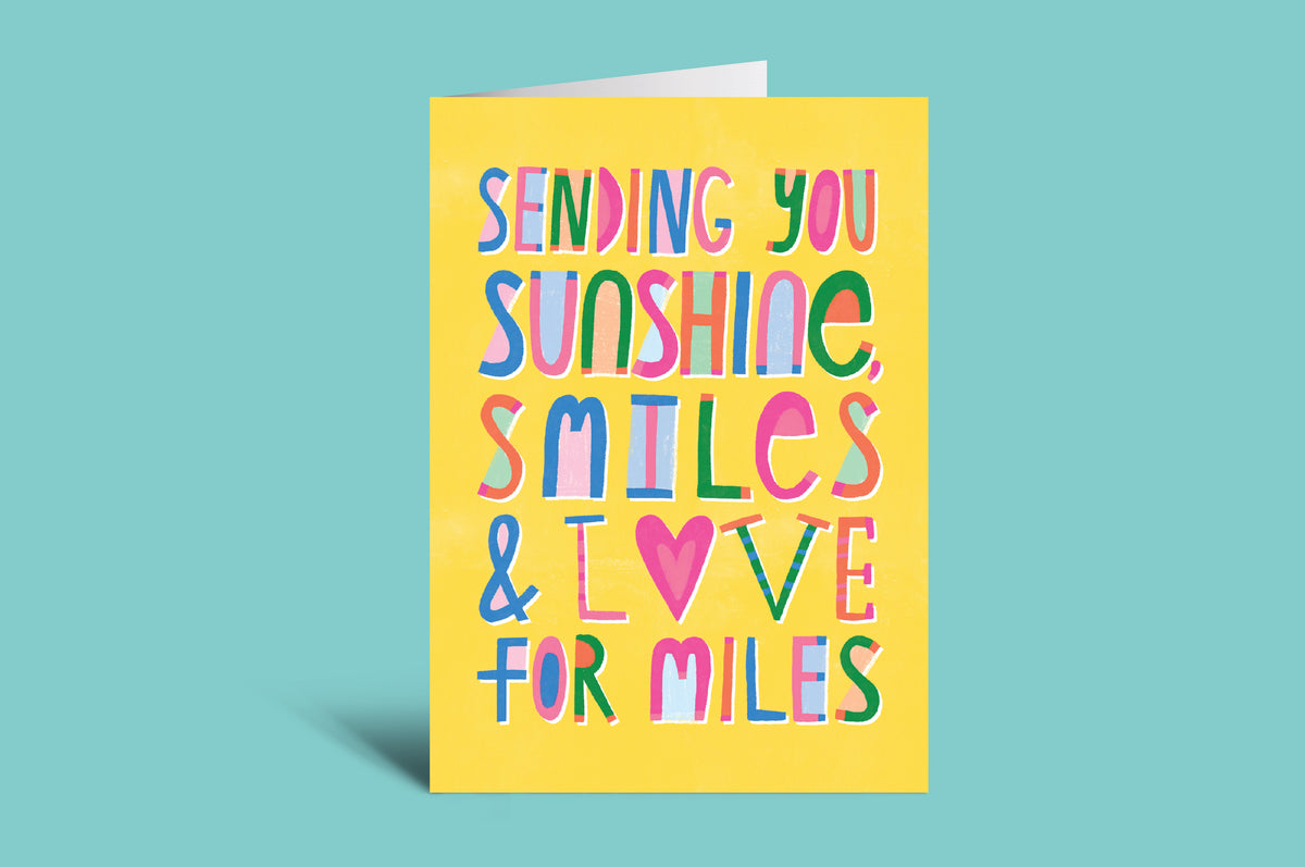 Colorful card with text 'Sending you sunshine, smiles & love for miles' on a green background