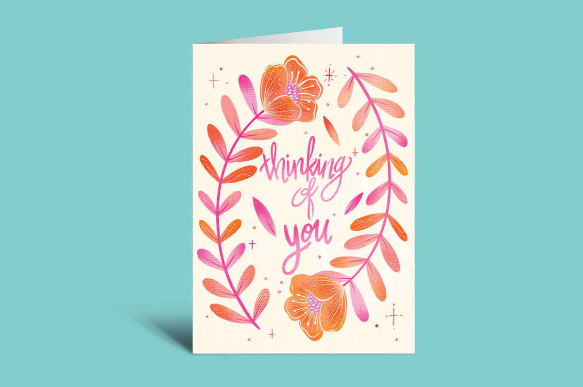 Greeting card with floral design and 'Thinking of you' text on a teal background