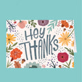 Card with 'Hey Thanks' text and floral design on a teal background