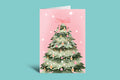 Christmas card with a decorated Christmas tree on a pink background