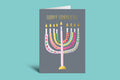 Greeting card with colorful menorah design and 'Happy Hanukkah' text on a teal background