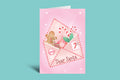Pink Christmas card with Santa Claus, gingerbread man, and candy cane on a green background