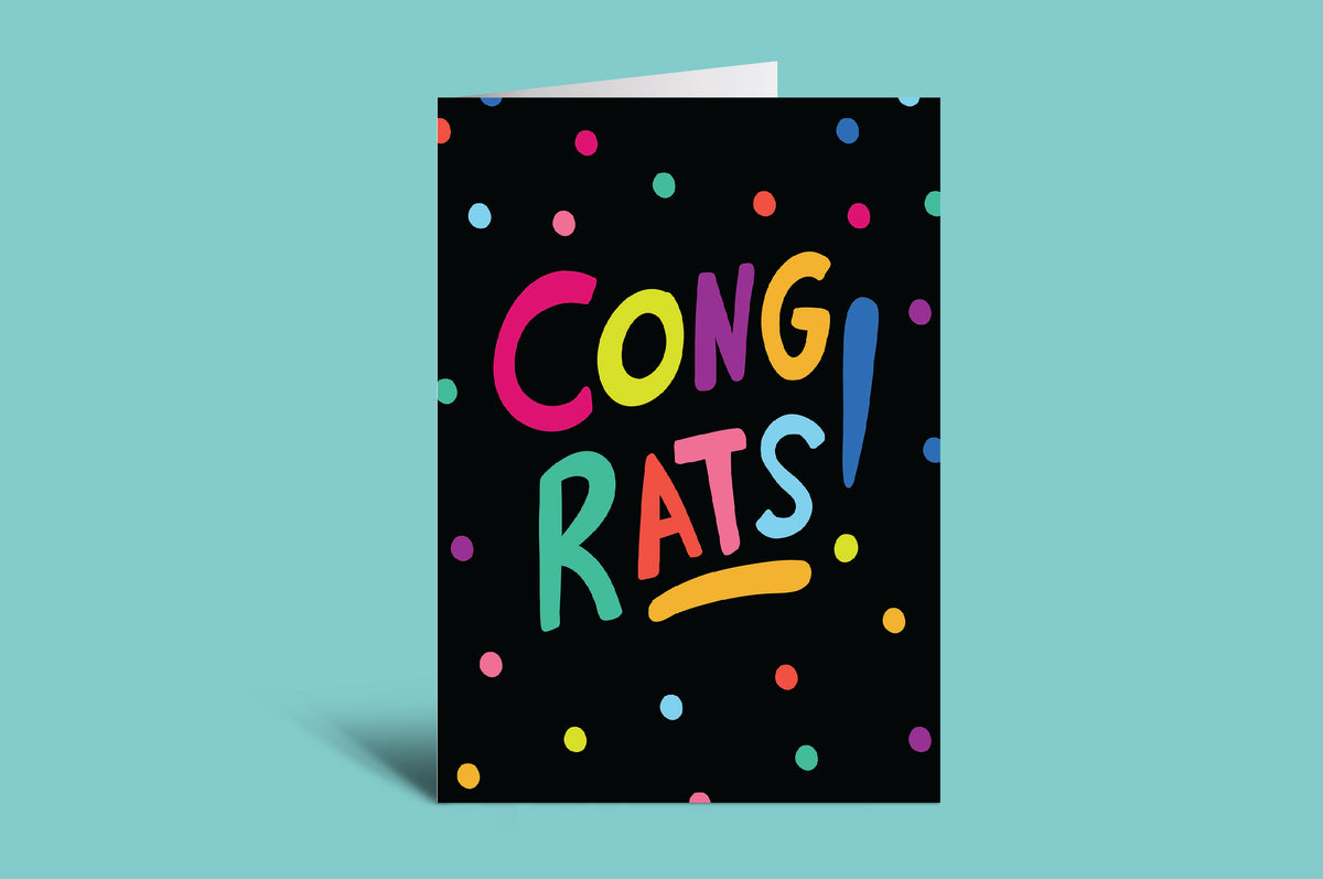 Greeting card with 'Congrats!' in colorful letters on a black background with polka dots, against a teal background.