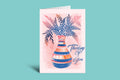 Greeting card with a vase and floral design on a pink background, against a teal border.