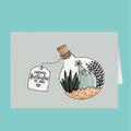 Greeting card with a cactus in a bottle and 'Happy Birthday to you' tag on a light blue background